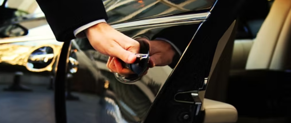 luxury car parked chauffeur opening door for client