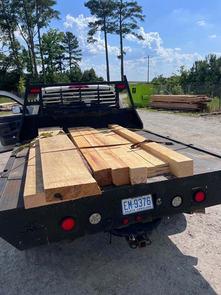 A truck is loaded with wood and has a license plate that says ew 9376