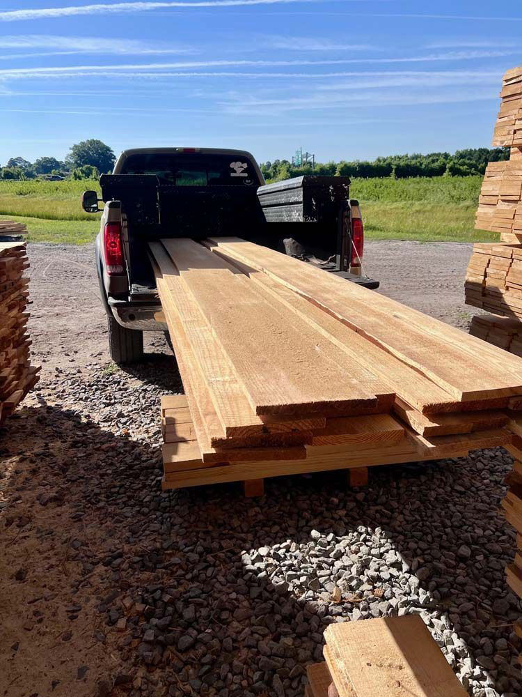A truck is carrying a large stack of wood.