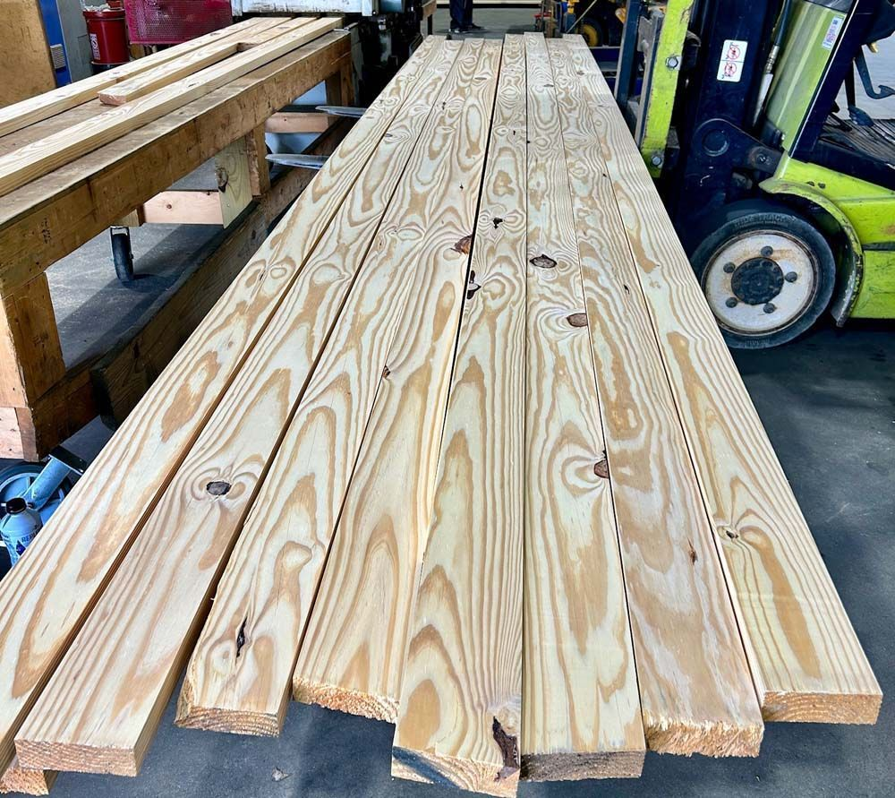 A stack of wooden boards is sitting next to a forklift.