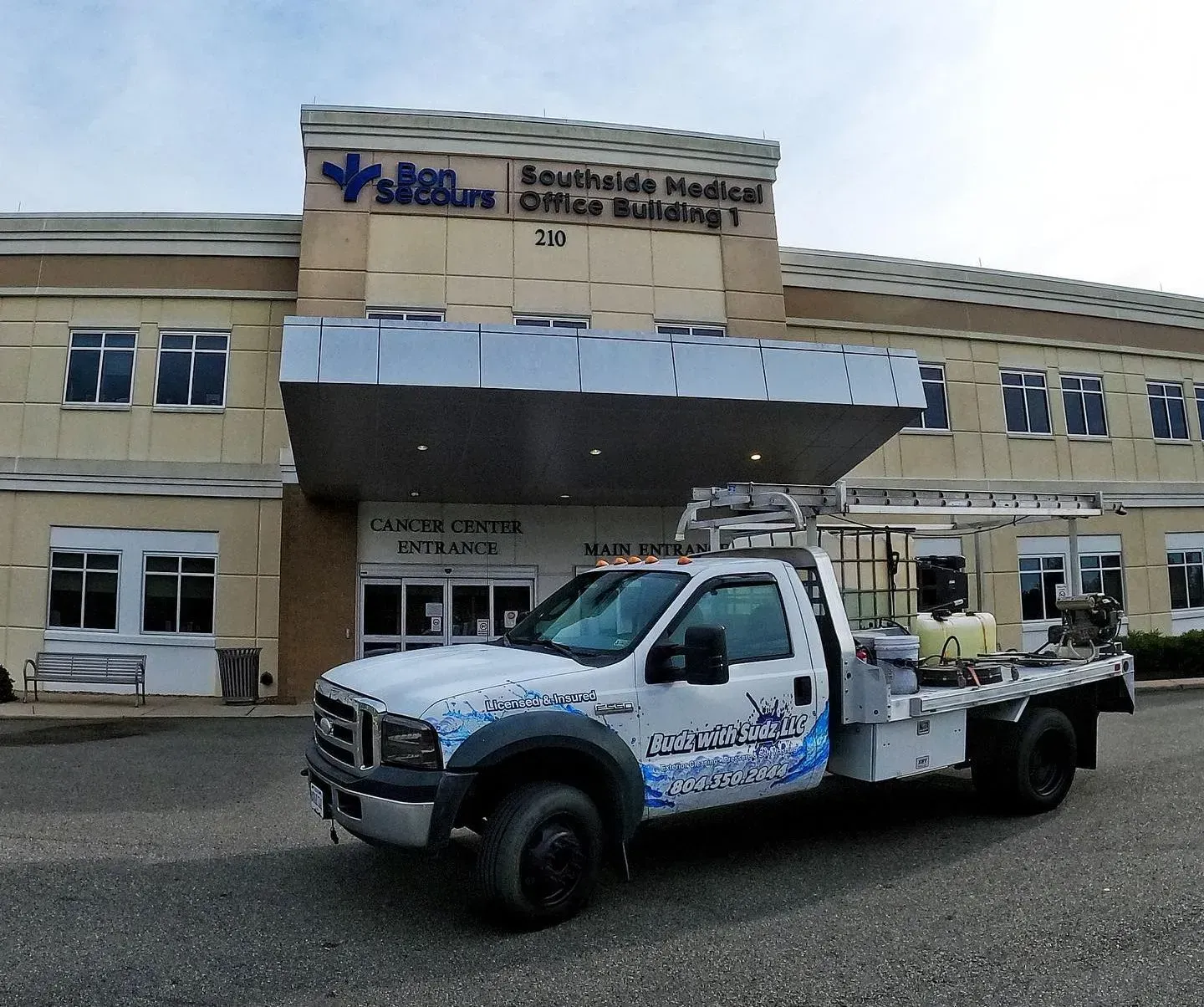 A white truck is parked in front of a hospital