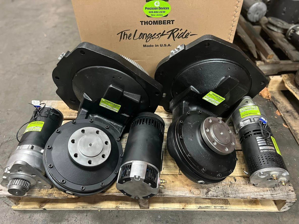 A bunch of motors are sitting on top of a wooden pallet.
