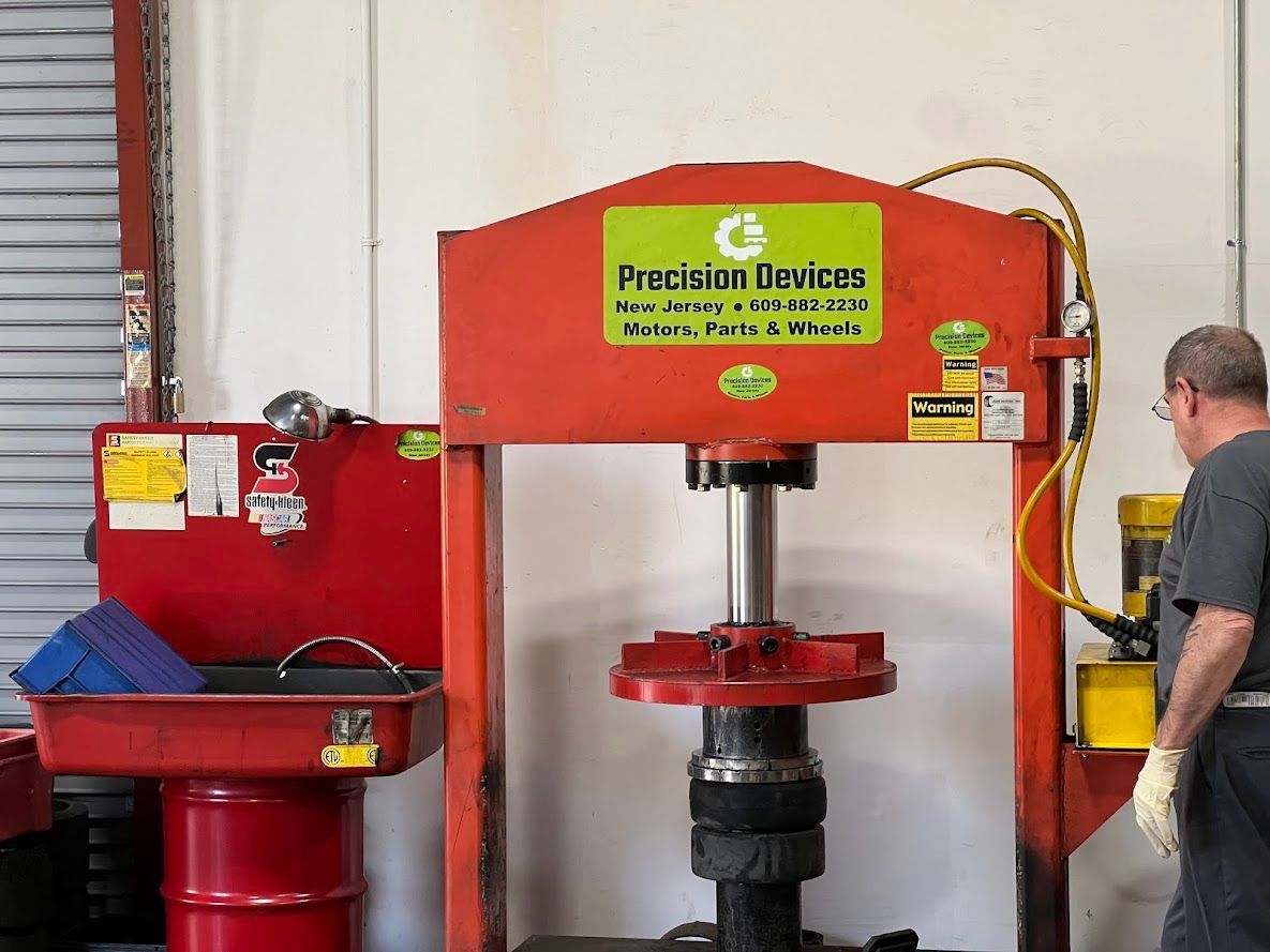 A man is standing in front of a machine that says precision devices on it.