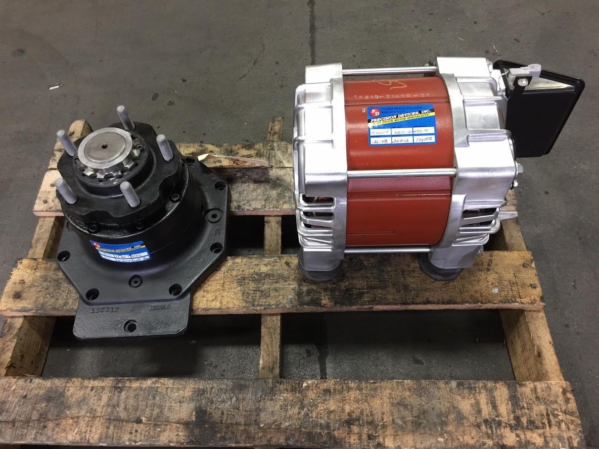 A motor is sitting on top of a wooden pallet.