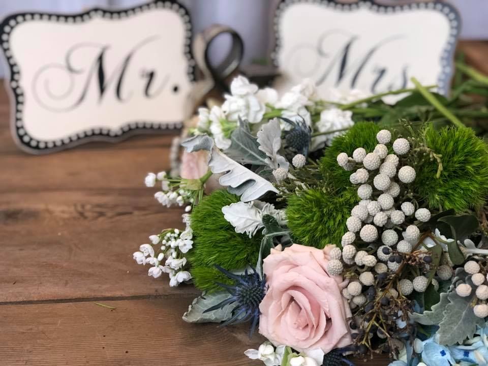 Wedding table decor with “Mr.” and “Mrs.” signs and a pastel floral arrangement