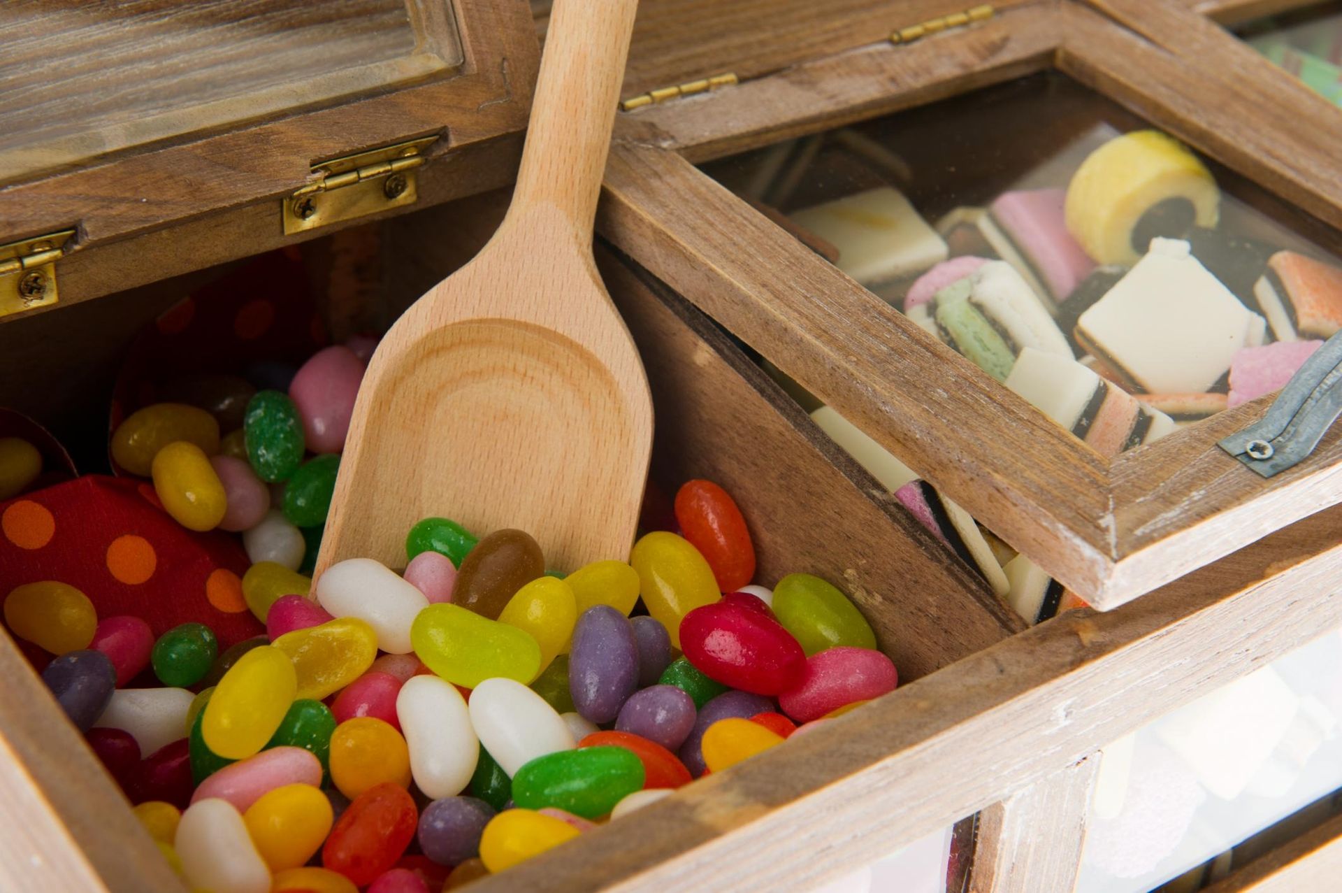 Wooden candy box with colorful jelly beans and a scoop