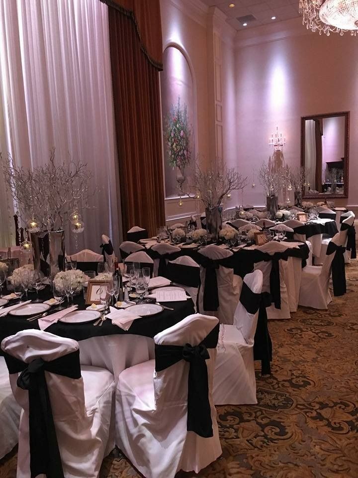 Elegant banquet hall with black-and-white table settings and chairs arranged for a formal event