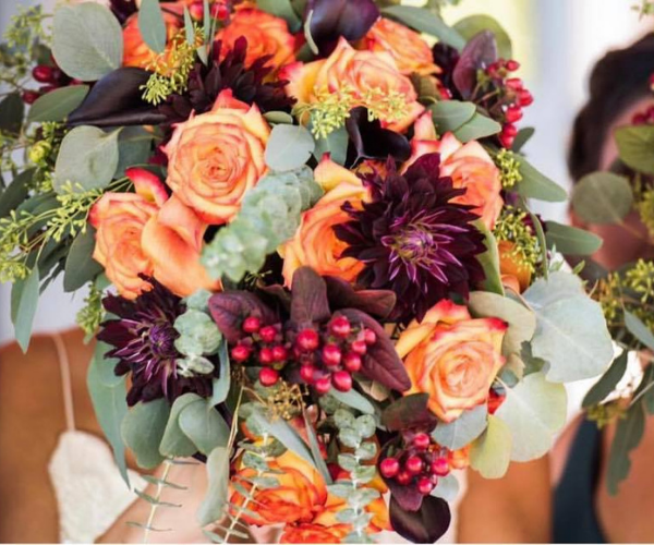 Autumn bouquet of orange, burgundy, and green flowers with berries and eucalyptus leaves