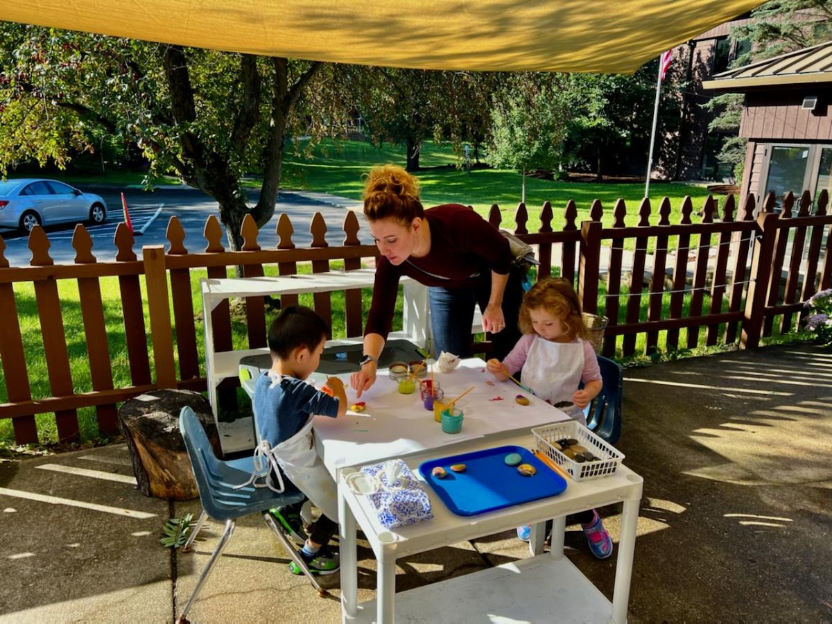 Montessori guide and children working outdoors