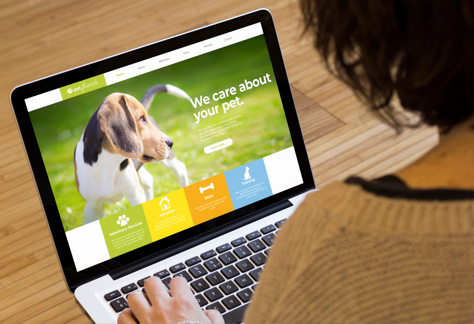 A woman is typing on a laptop computer with a dog on the screen.