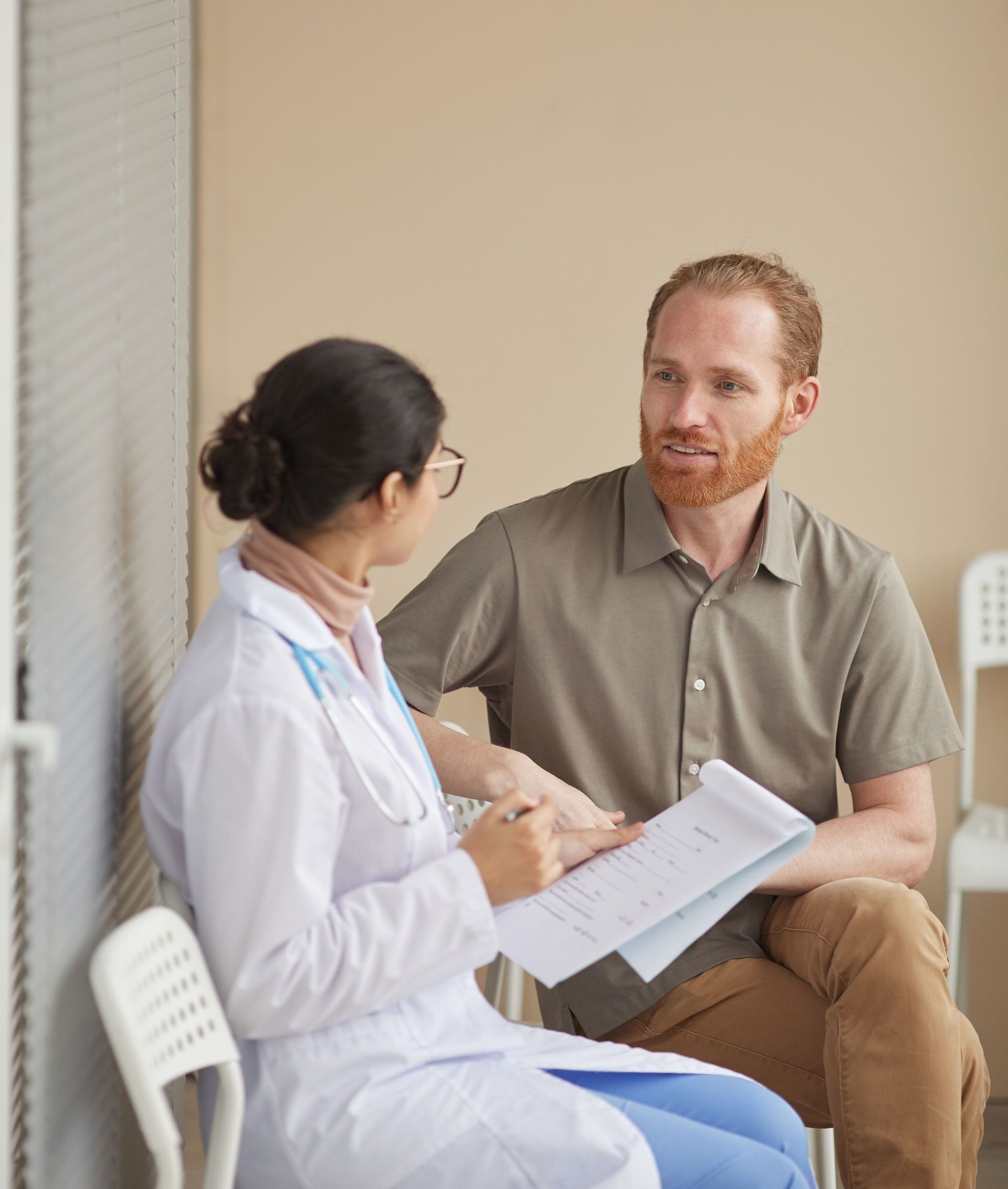 A doctor is talking to a patient in a waiting room.