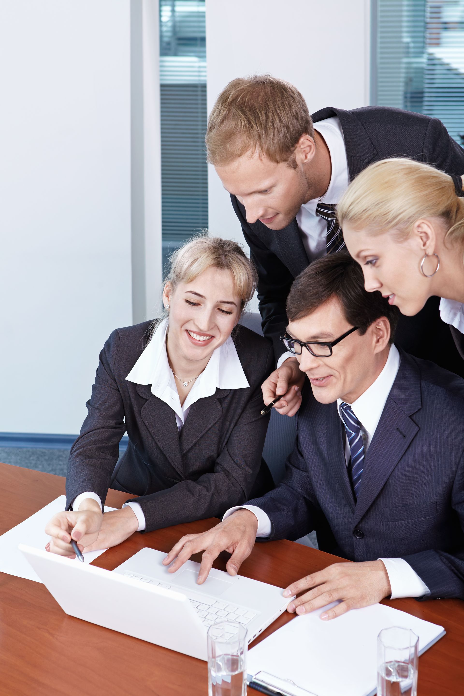 A group of business people are looking at a laptop computer
