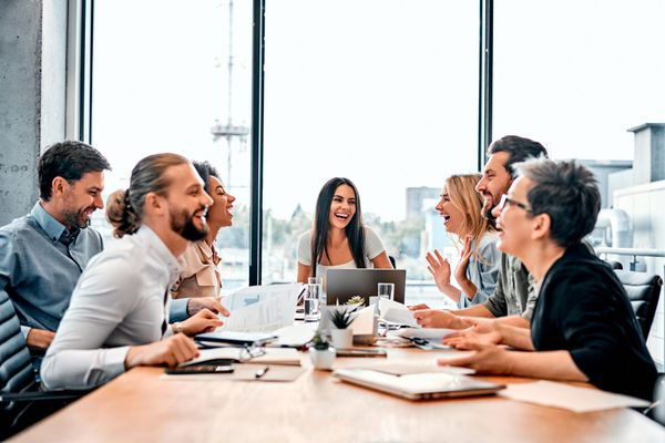 A group of people are sitting around a table having a meeting.