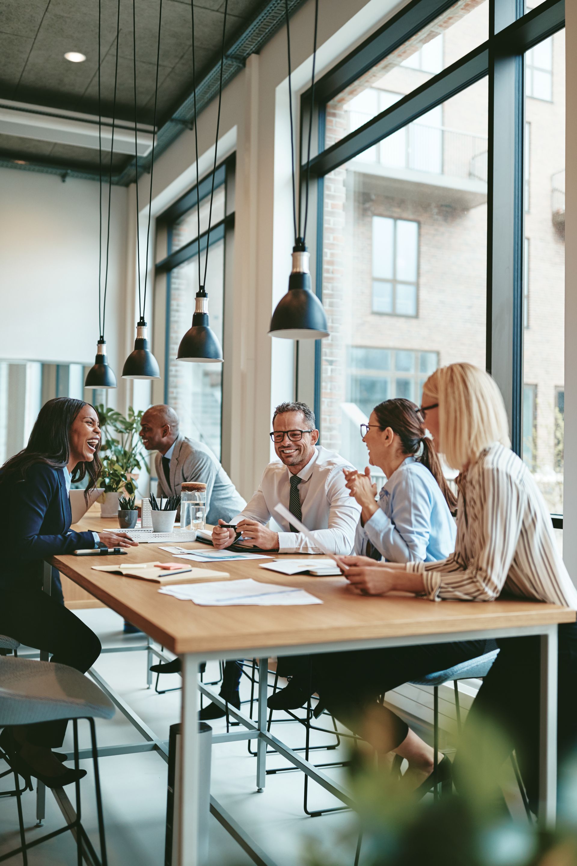 A group of people are sitting around a table having a meeting.