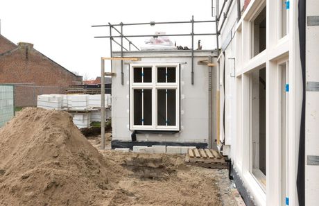 a pile of dirt next to a building under construction