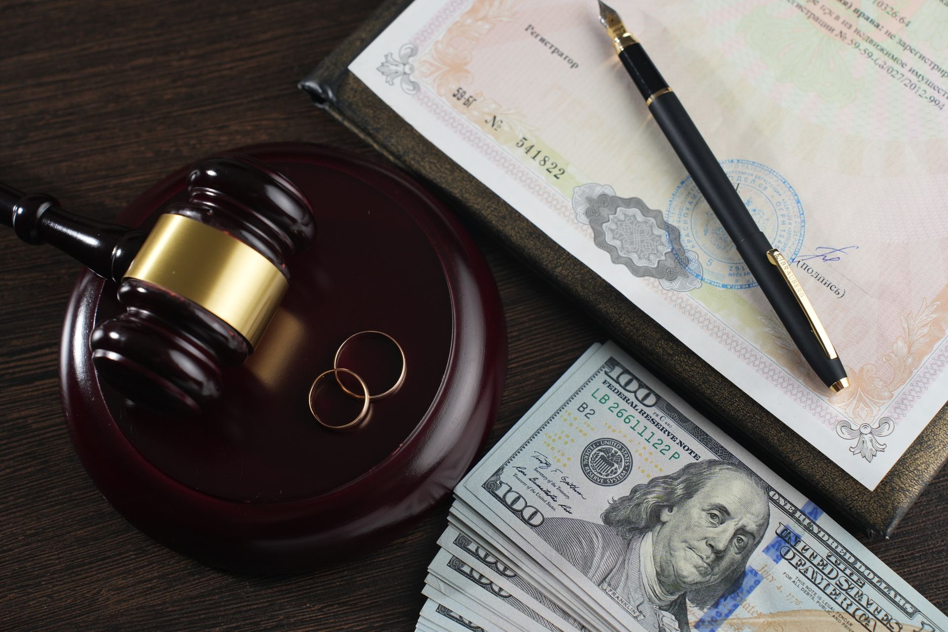 Wedding rings beside a gavel, symbolizing divorce and property division.