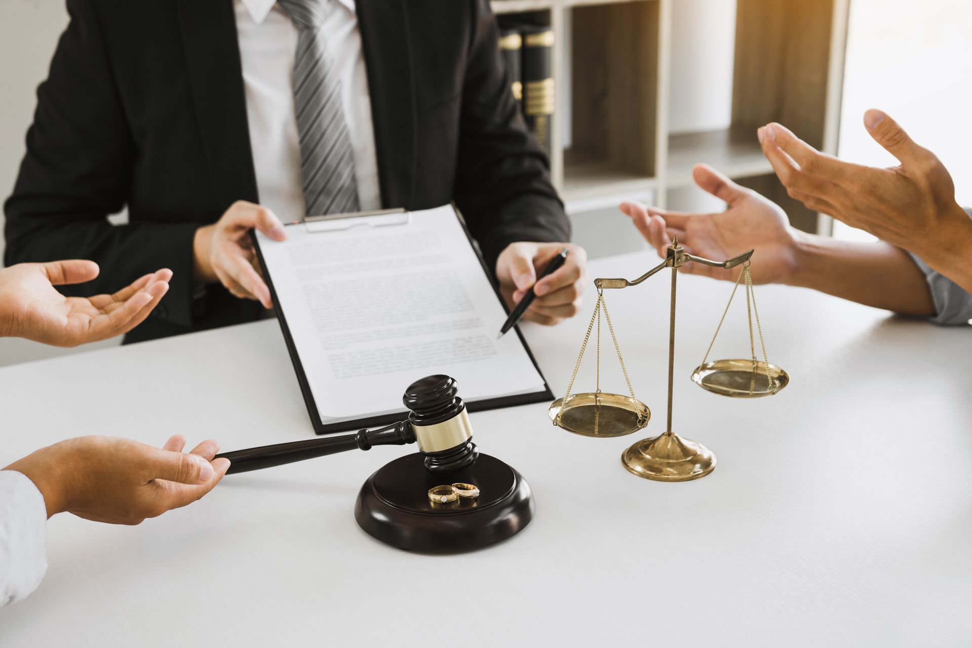 Lawyer mediating a divorce discussion between a couple with gavel and scales. Lawyer mediating a divorce discussion between a couple with gavel and scales.