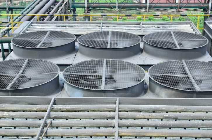 Six large industrial cooling fans on a metal rooftop platform.
