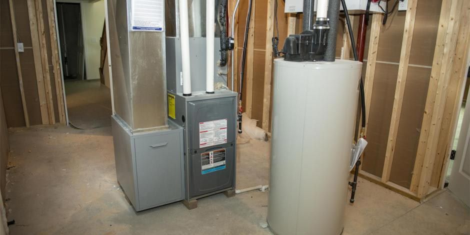 Basement utility room with furnace, water heater, and exposed framing
