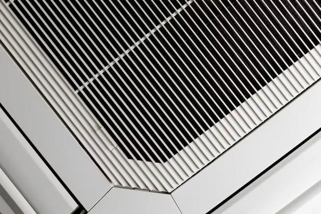 Close-up of a white metal vent grille with diagonal corner trim and black slats