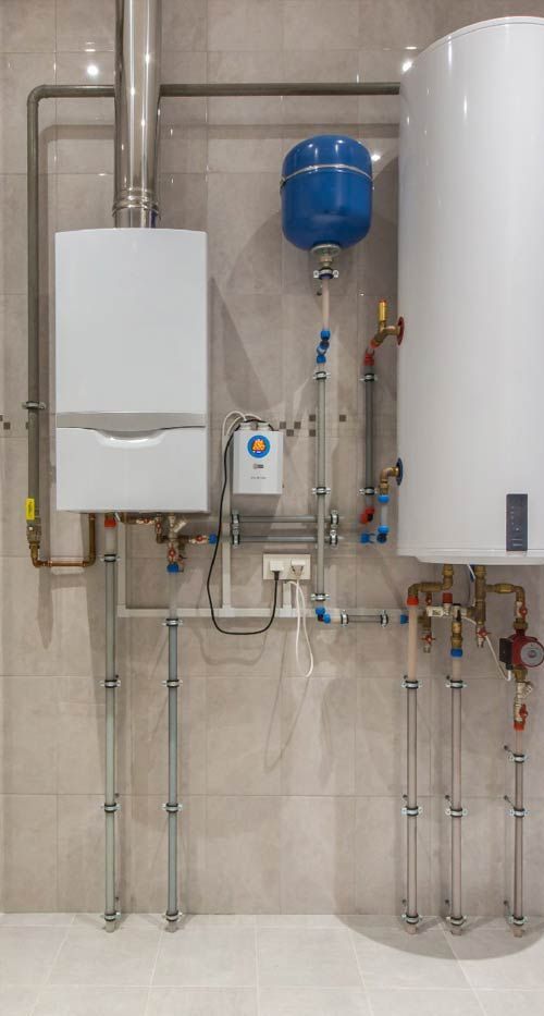 Wall-mounted boiler, water heater, and blue expansion tank in a tiled utility room
