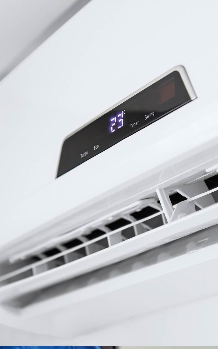 Wall-mounted white air conditioner with digital display and open vent louvers