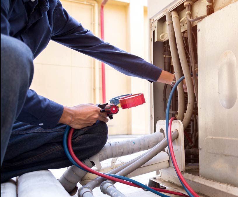 Technician using a red hose to inspect plumbing pipes under a sink