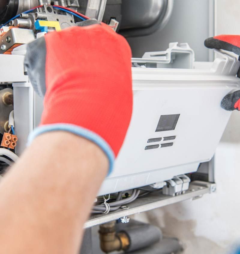 Gloved hands working on a white machine panel with exposed wiring inside a vehicle or equipment bay