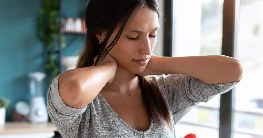 Woman holding neck and shoulders showing physical stress tension and fatigue.