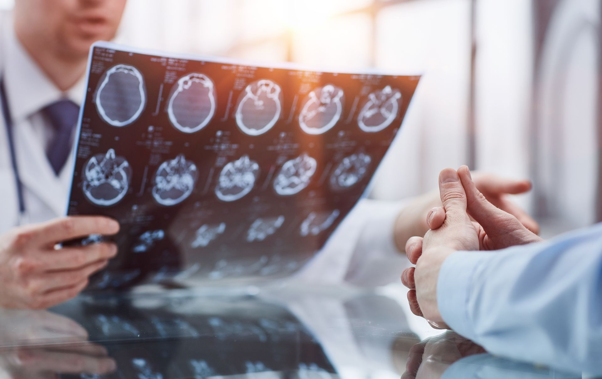 Doctor reviewing brain scan images with a patient in a medical office