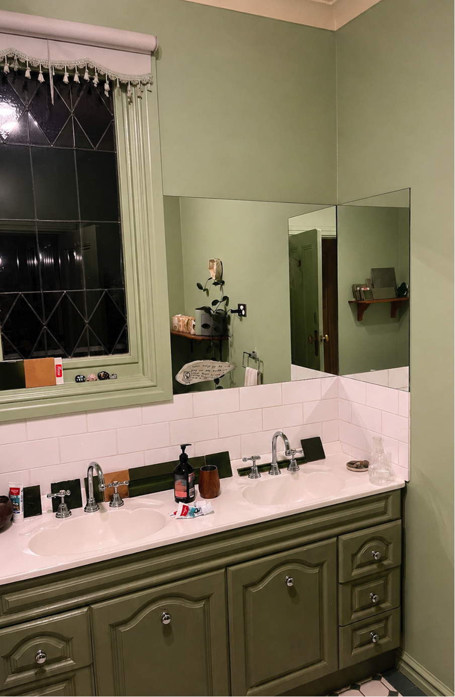 Green bathroom ready for a renovation, white vanity bench with green cabinets and sash window