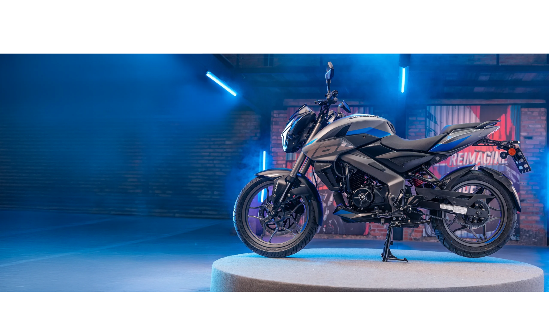 Black sport motorcycle on a lit display platform with blue neon lighting in a garage-like setting