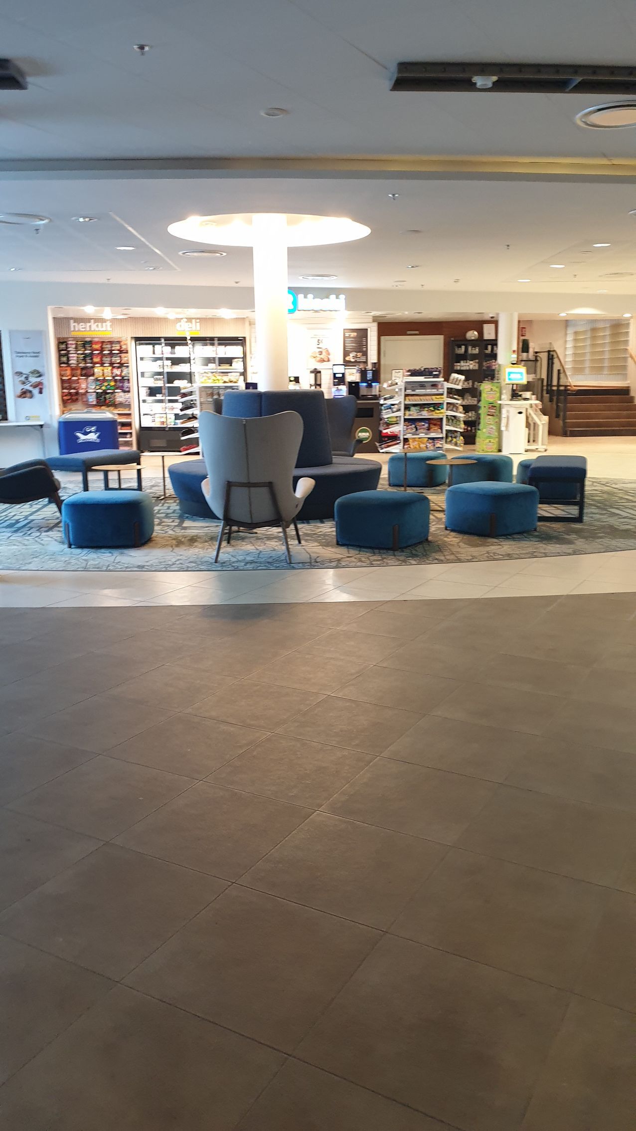 A large room with a lot of chairs and ottomans in it.