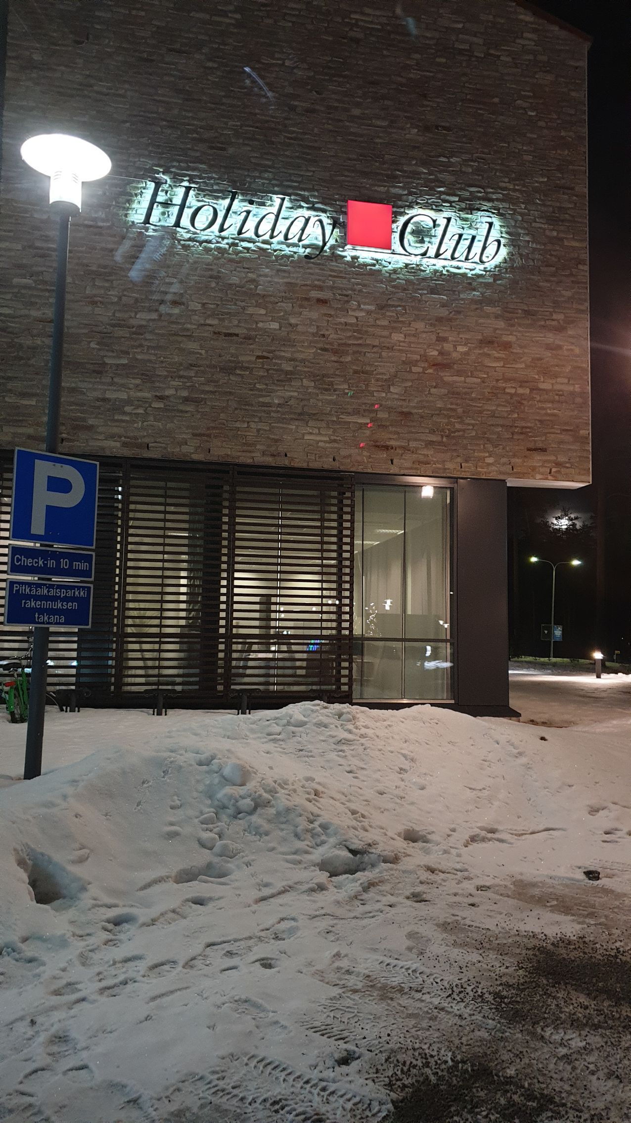 A building with a lot of snow on the ground in front of it.