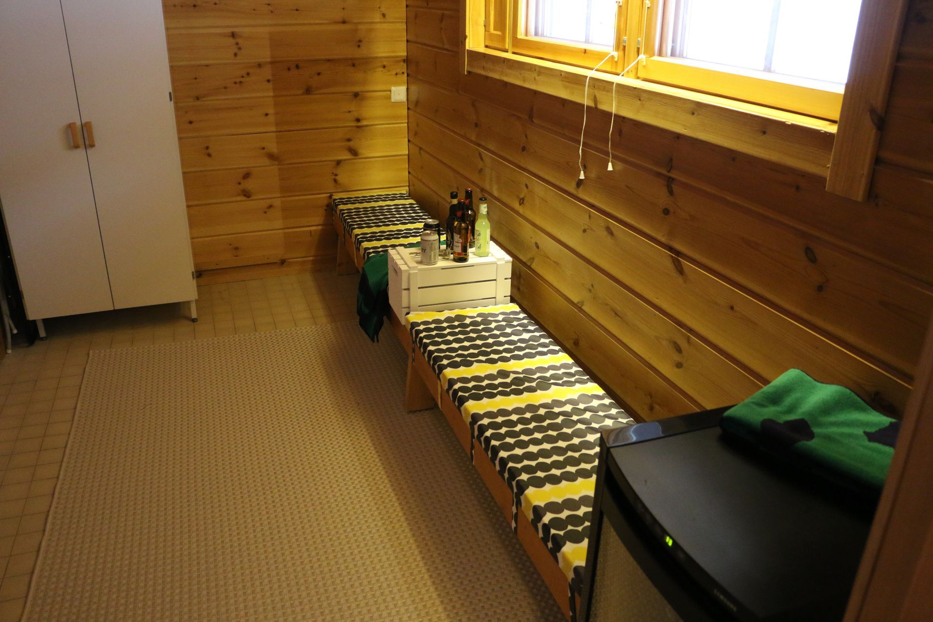 A bedroom with two beds and a small refrigeratore