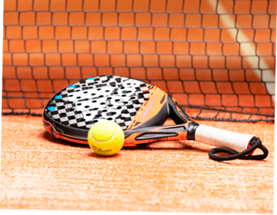 A tennis racket and ball are on a tennis court in front of a net.