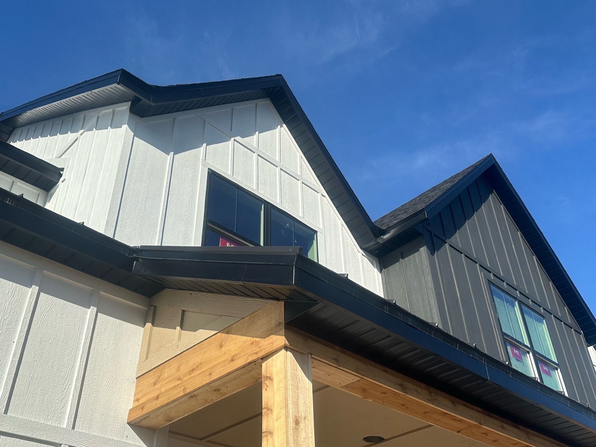 A white and black house with a blue sky in the background.