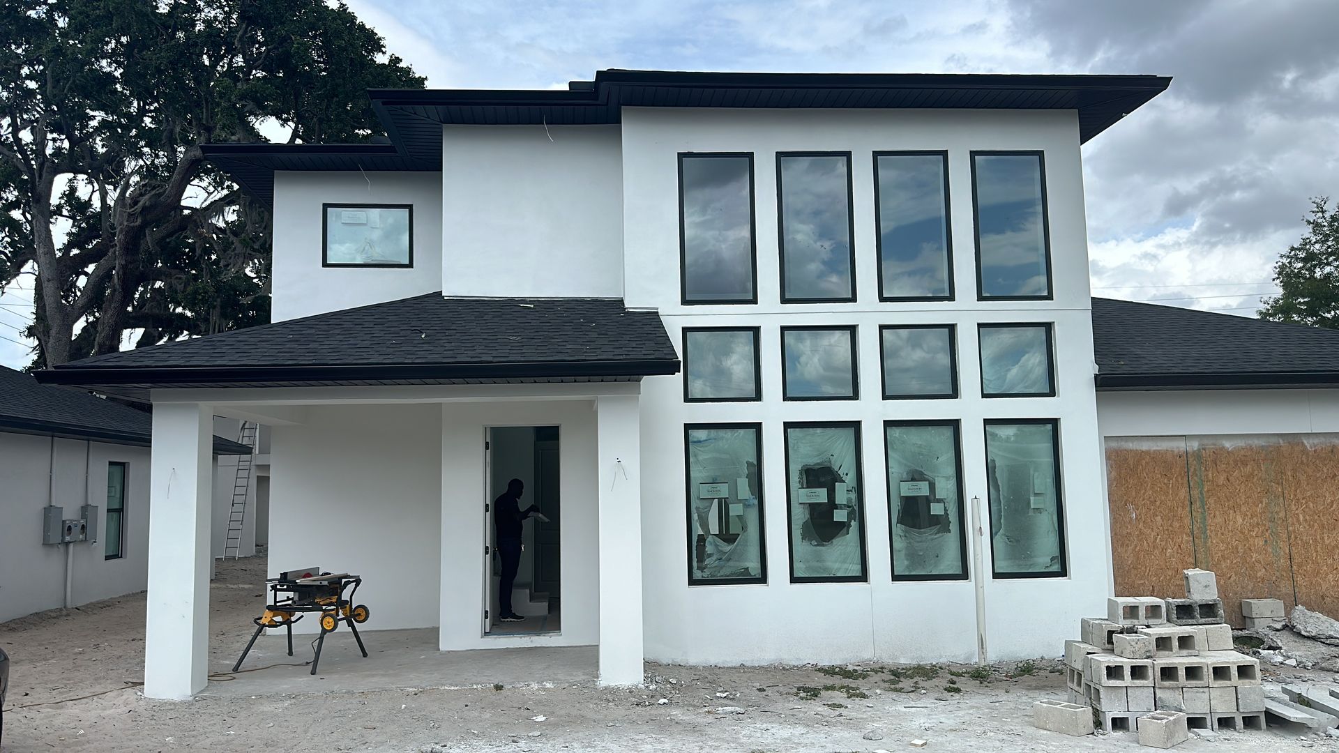 A white house with a lot of windows is being built.