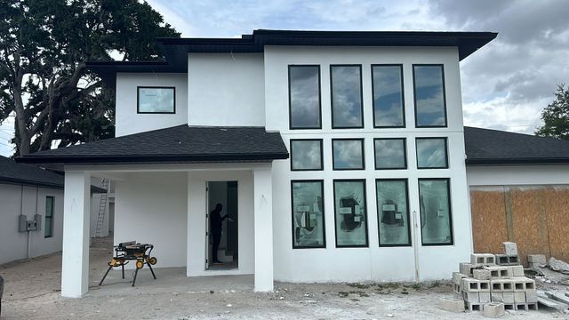 A white house with a lot of windows is being built.