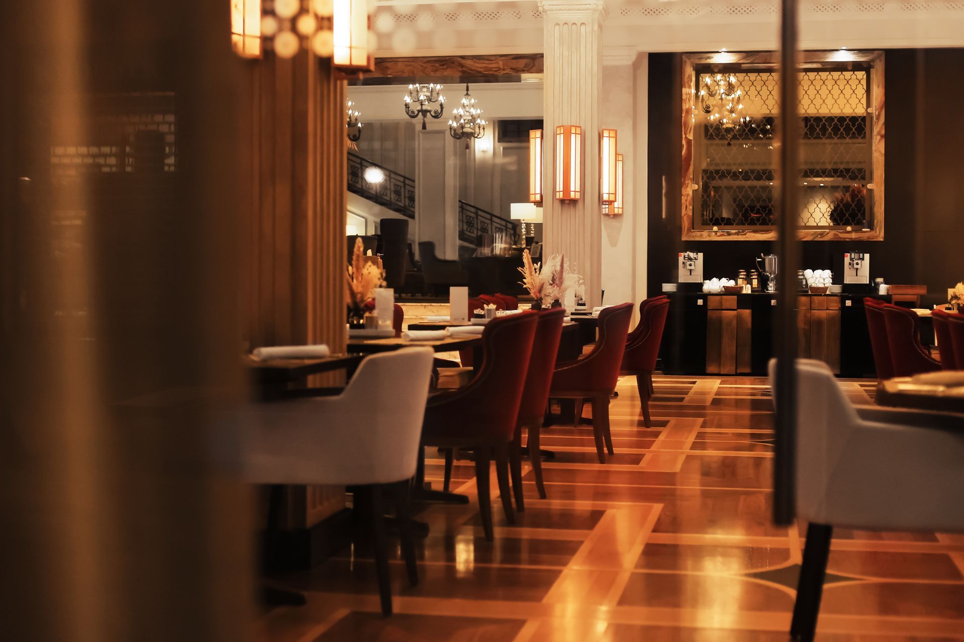 Elegant restaurant interior with warm lighting, polished floors, and neatly set tables and chairs