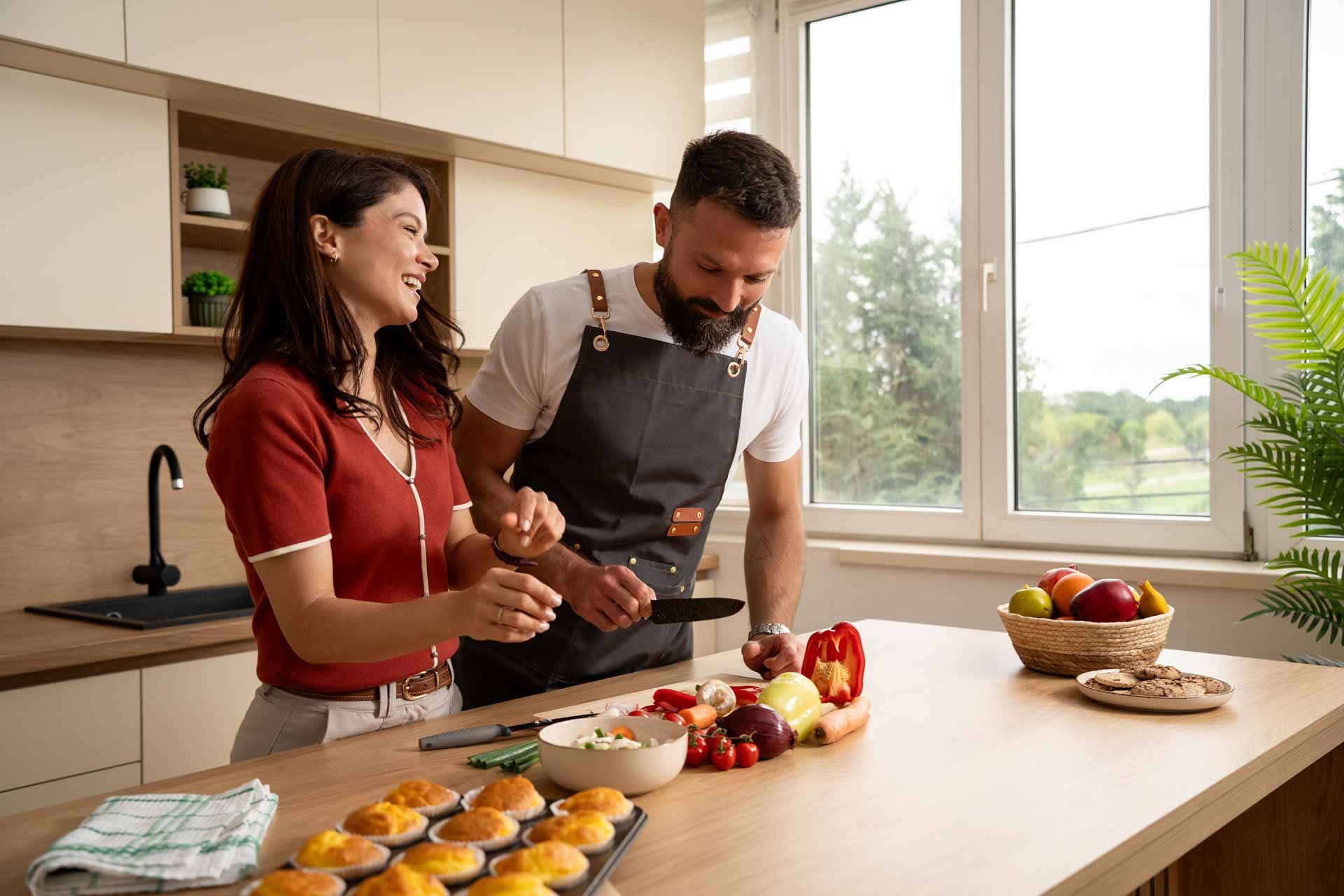 Two people decorating fruit tarts together in a bright kitchen Two people decorating fruit tarts together in a bright kitchen