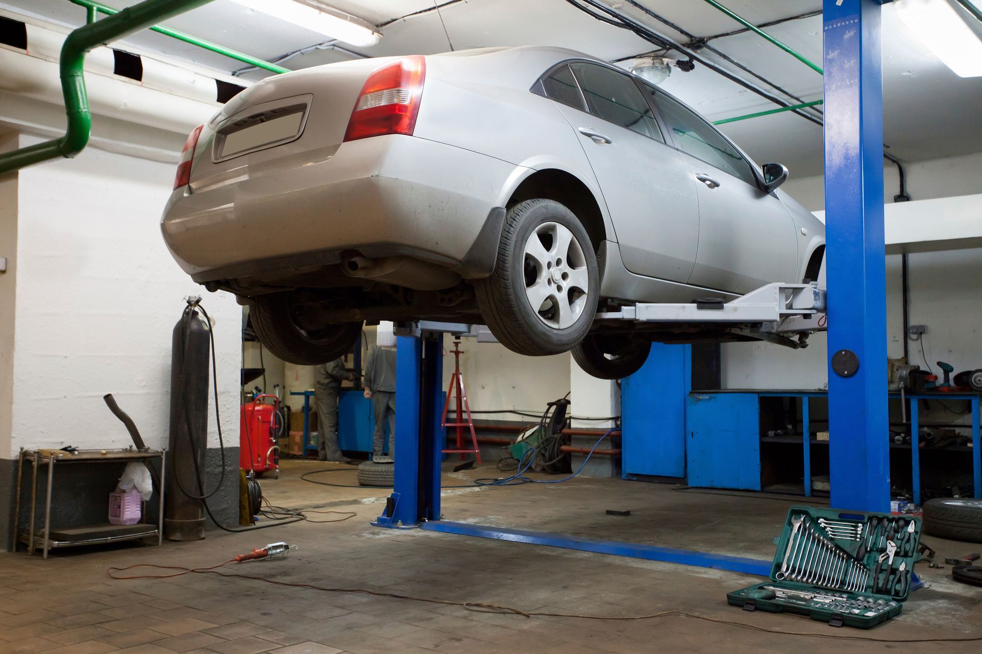 A man is working on a semi truck in a garage. A man is working on a semi truck in a garage.