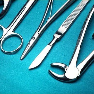A set of surgical instruments on a blue surface