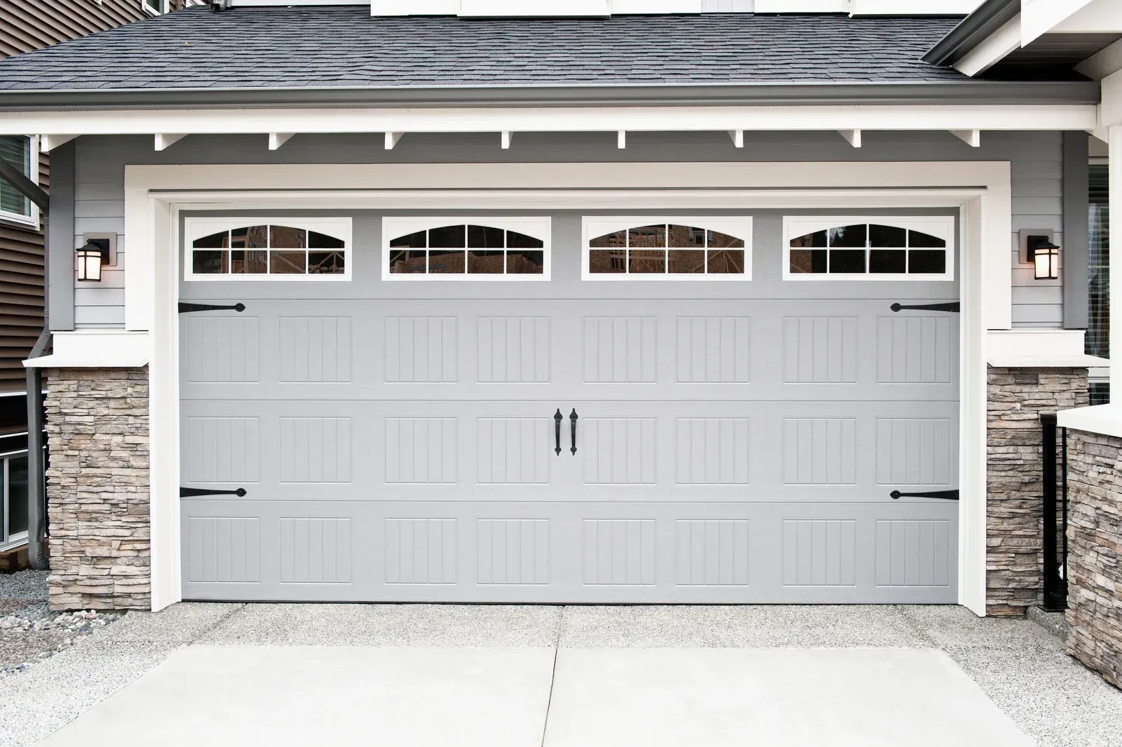 Gray garage door with decorative windows and hardware.
