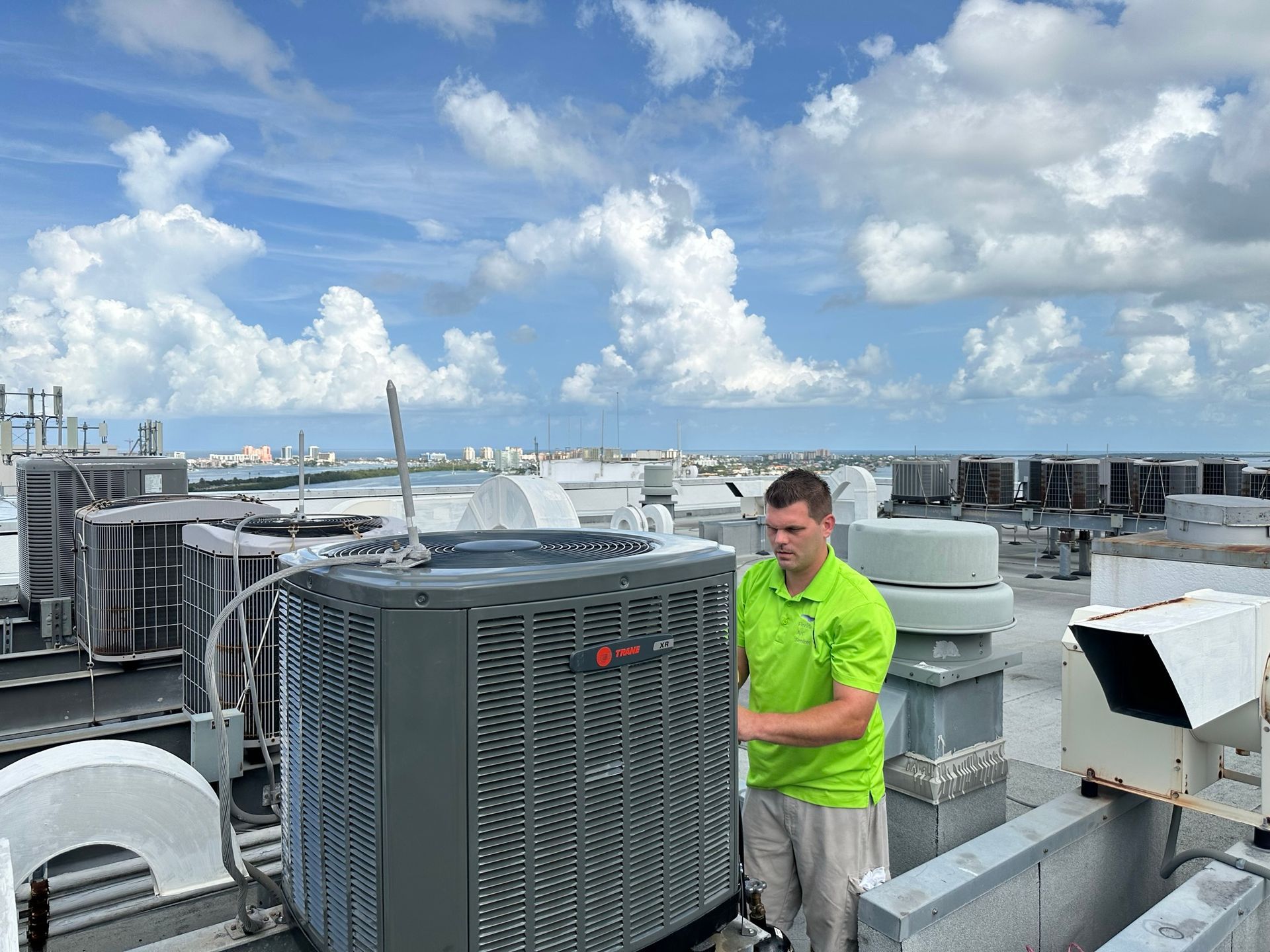 Technician servicing commercial HVAC unit on rooftop