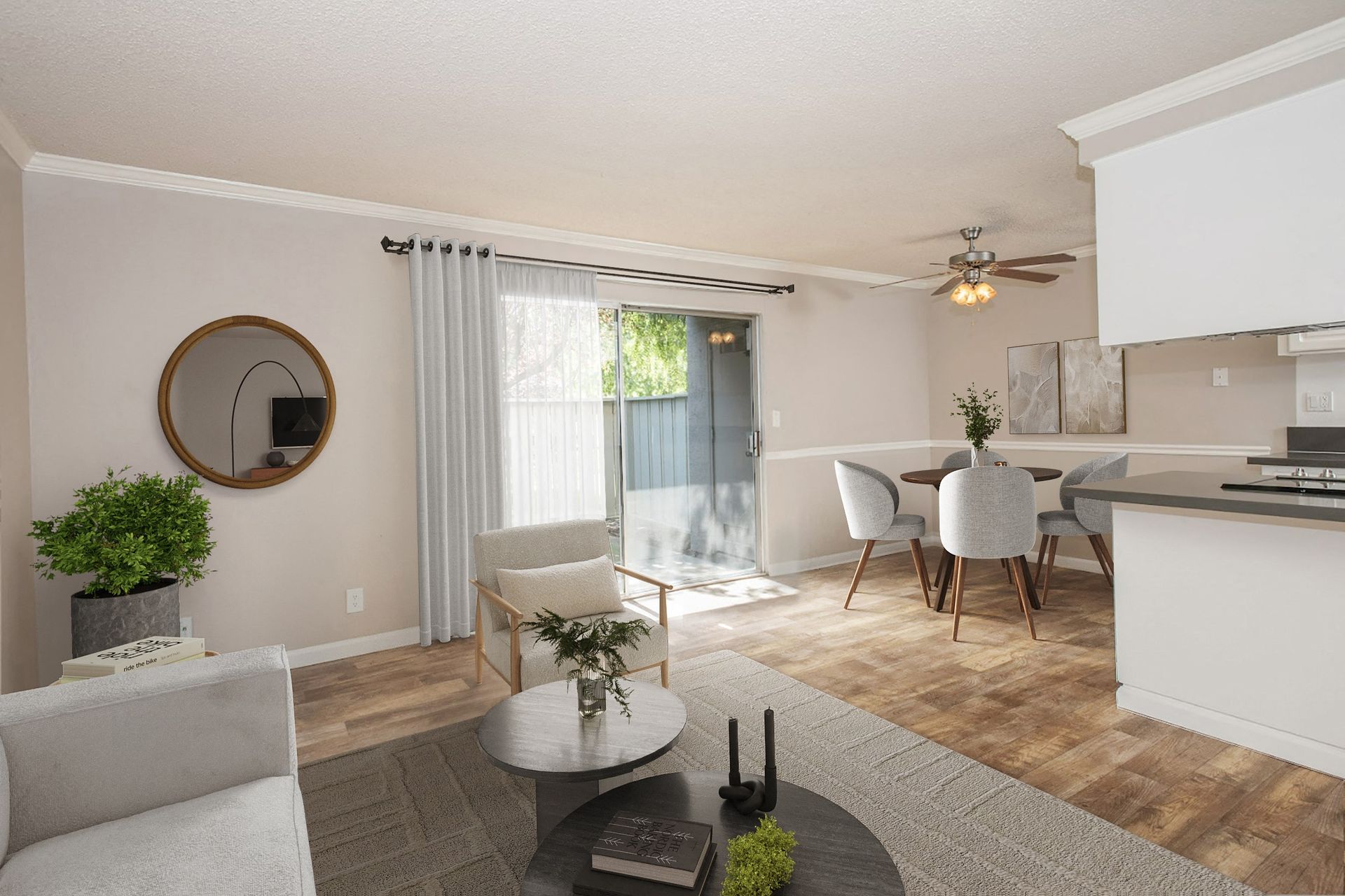 Open living room with neutral furnishings, dining area, and a sliding glass door to the patio at Valley Ridge Apartments.