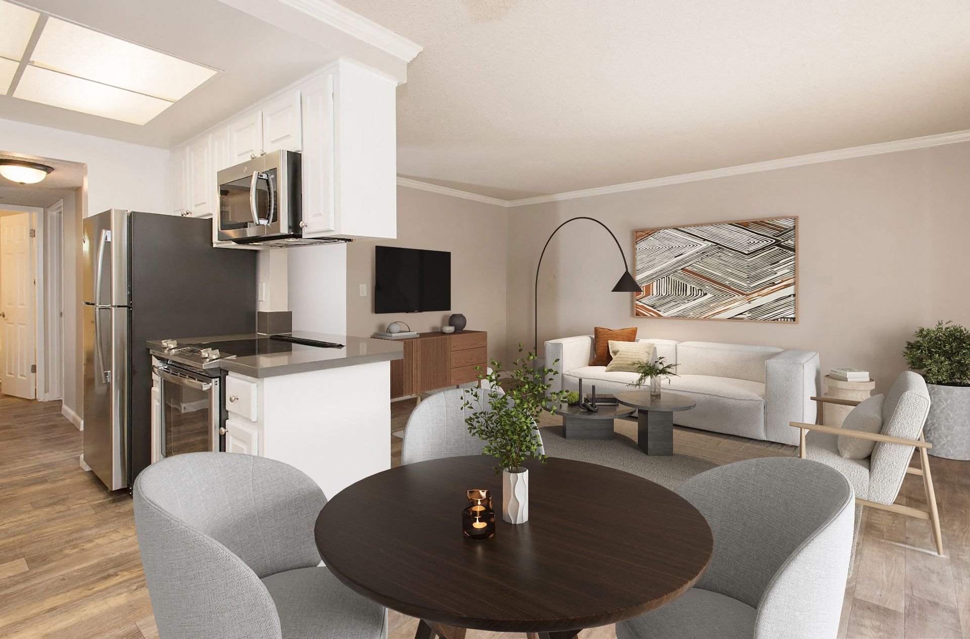 Open-concept living area with round dining table, gray chairs, and kitchen in the background at Valley Ridge Apartments.