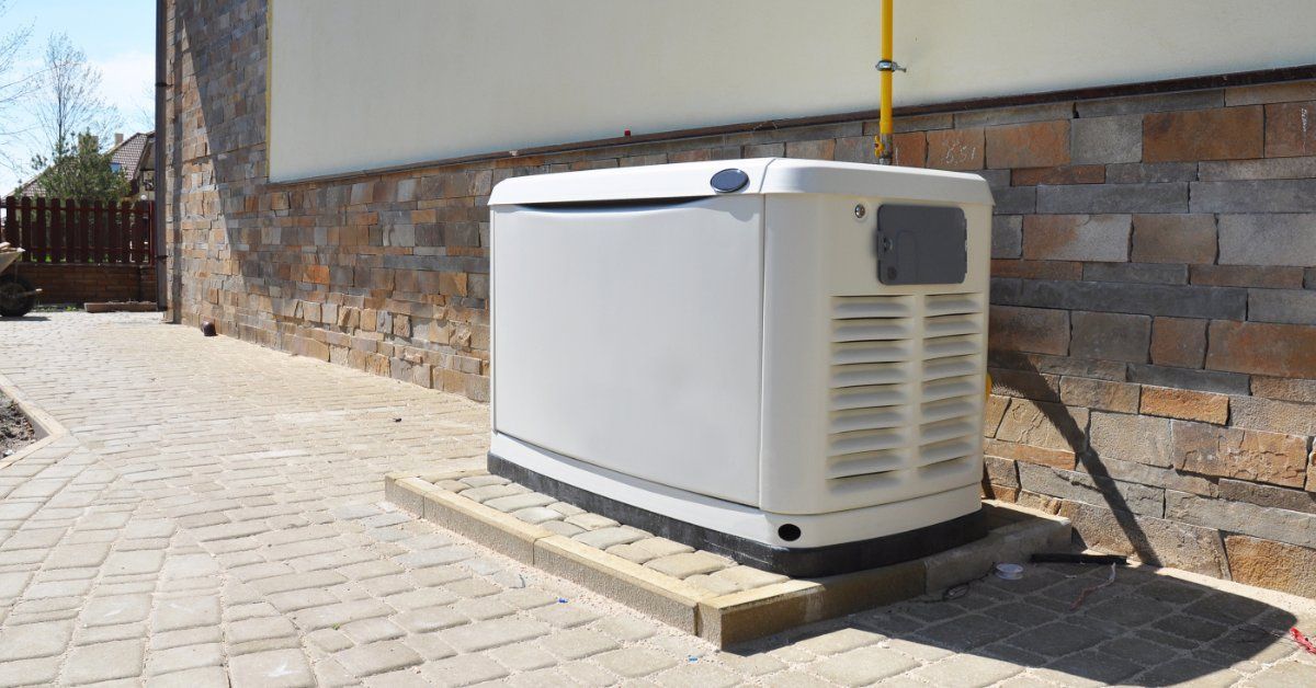 A white natural gas backup generator outside a house on a brick pedestal on a brick walkway around t