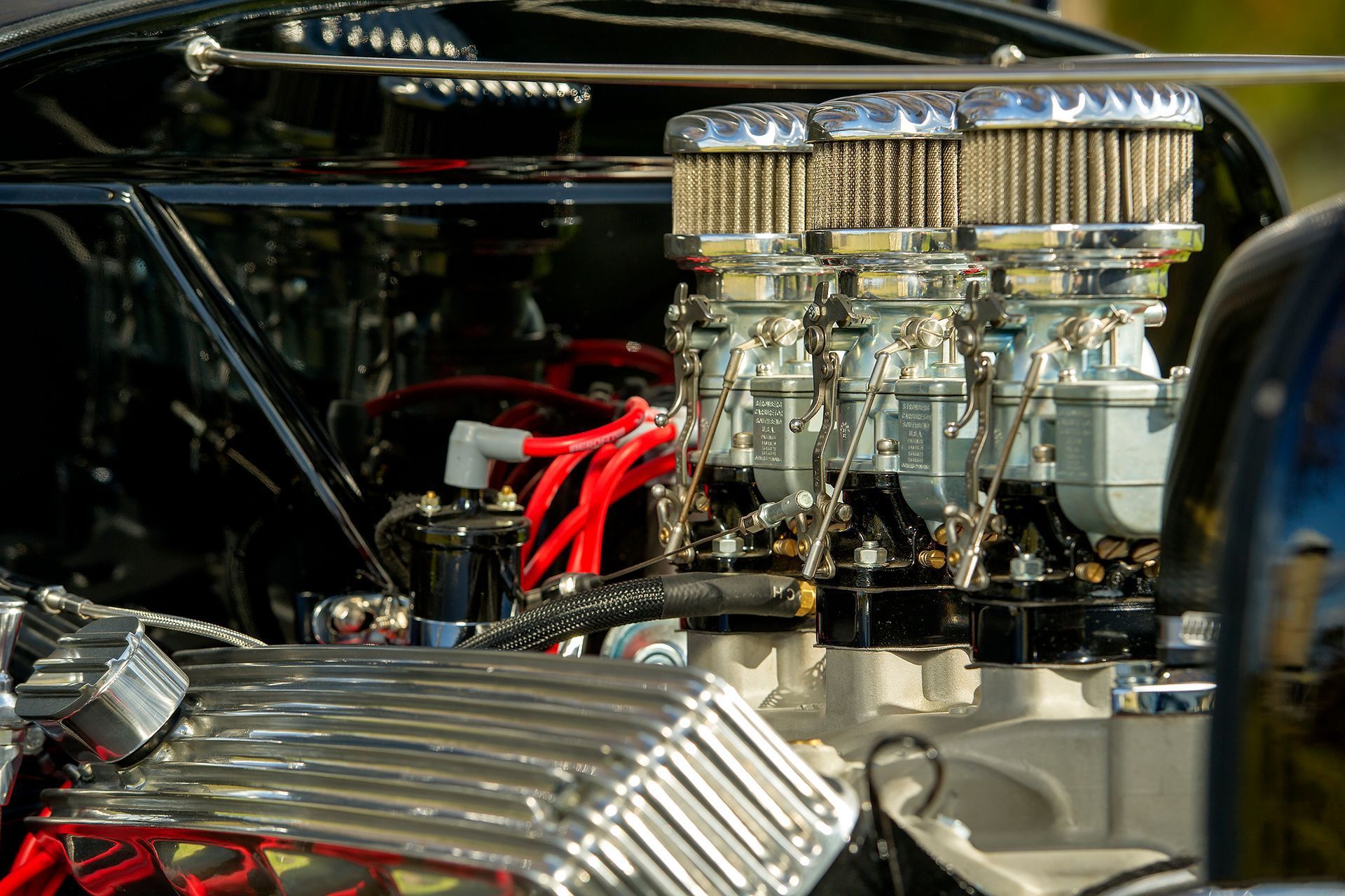 Chrome car engine with red wires and polished air intake components