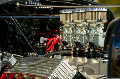 Chrome car engine with red ignition wires and polished air filter under the hood